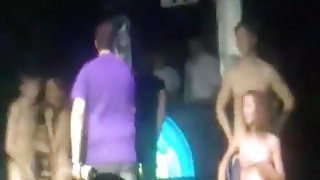 2 russian couple have a striptease game on stage in a disco